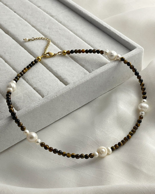 A gold chain necklace with brown tiger eye beads and white pearl accents.
