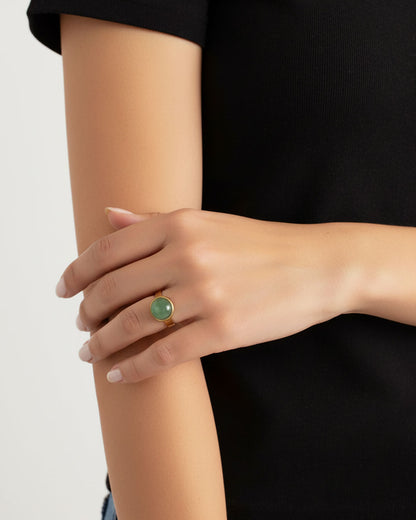 Hand wearing a gold waterproof adjustable band ring with an aventurine stone