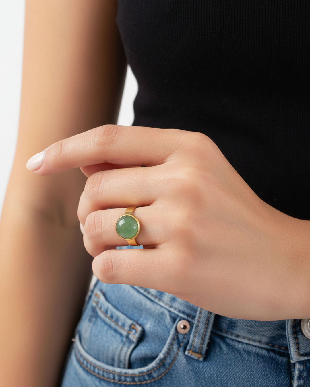 Hand wearing a gold waterproof adjustable band ring with an aventurine stone
