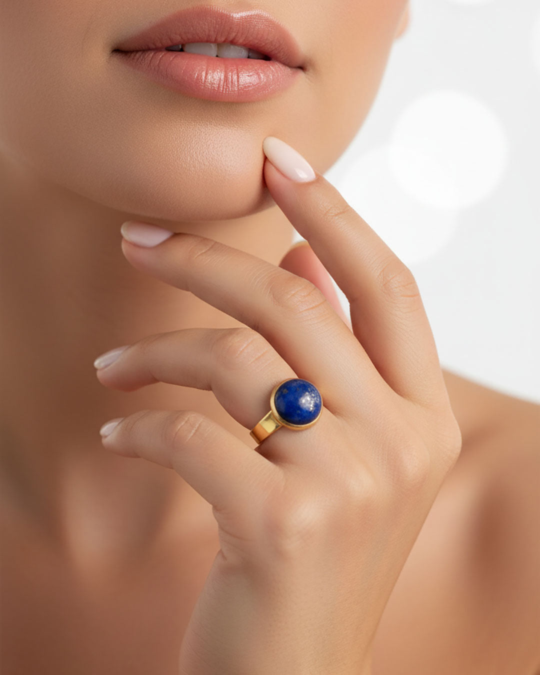 Hand wearing a gold waterproof adjustable band ring with a lapis lazuli stone