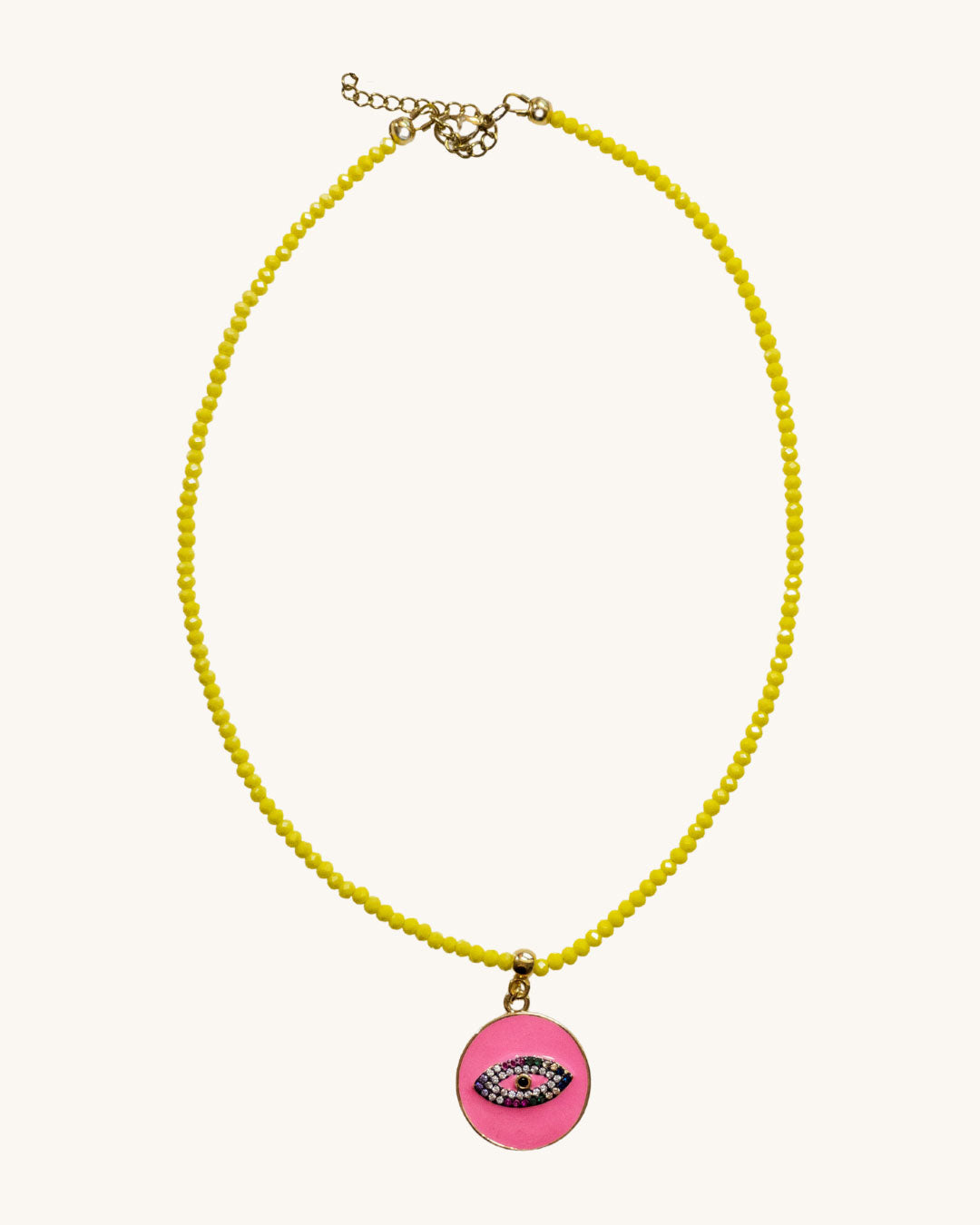 A yellow beaded necklace with a fuchsia round eye pendant.