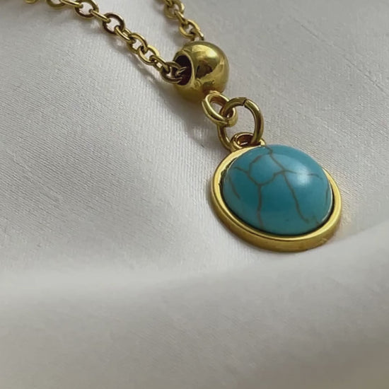 A turquoise pendant necklace in gold