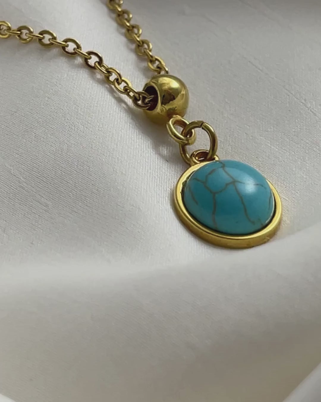 A turquoise pendant necklace in gold