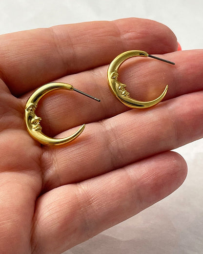 The Crescent Moon Earrings, a pair of half-moon-shaped gold earrings
