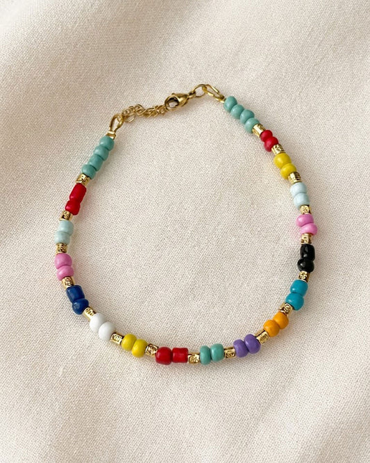 A colorful glass beaded anklet adorned with gold metal beads