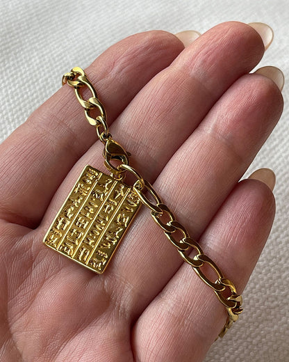 Egyptian style chain bracelet with a tag charm in gold