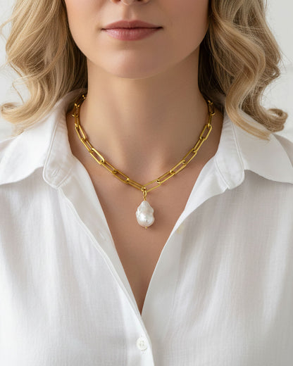 Model wearing a gold chunky chain necklace with a large baroque pearl in the middle