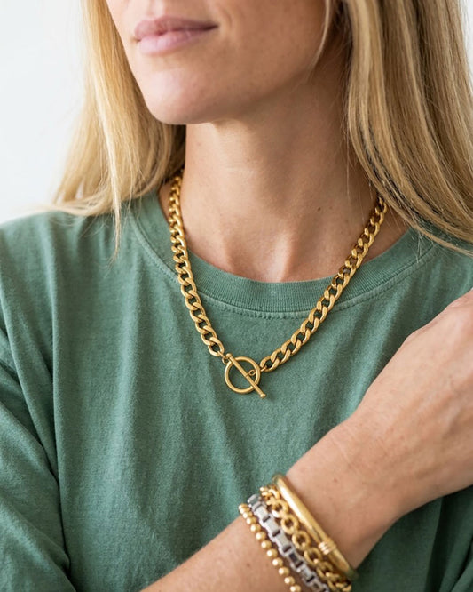 Model wearing a chunky gold toggle necklace