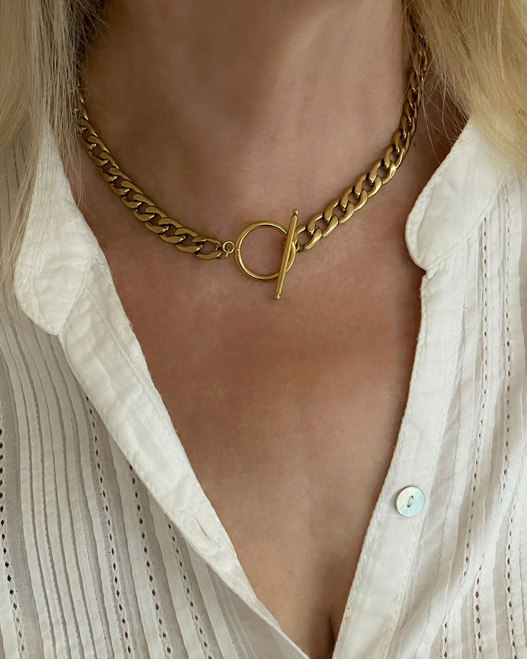 Model wearing a chunky gold toggle necklace