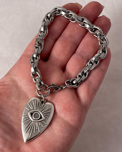 A close-up look of our evil eye heart charm bracelet with a silver chunky chain