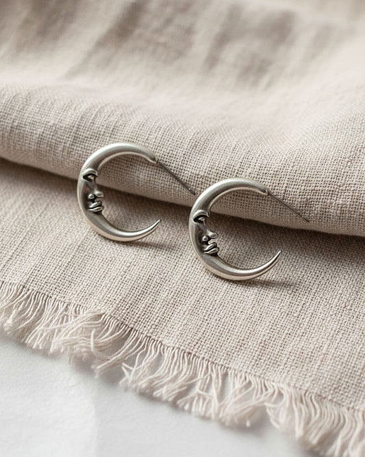A pair of half-moon-shaped silver earrings