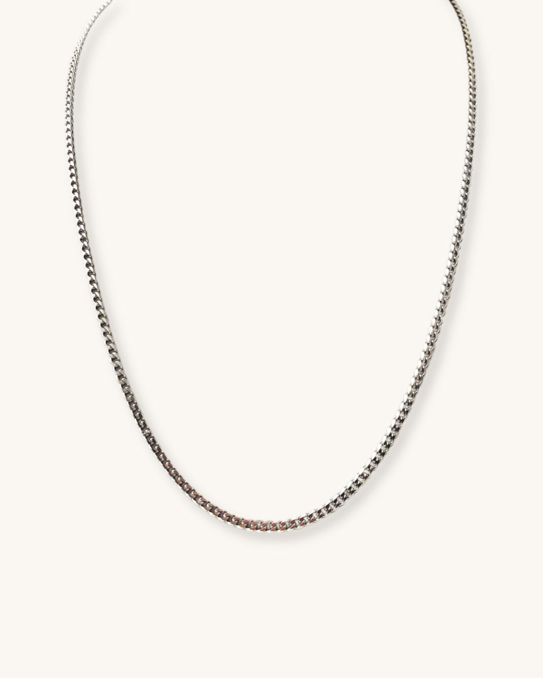 Silver curb chain necklace on a white background