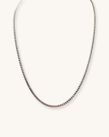 Silver curb chain necklace on a white background