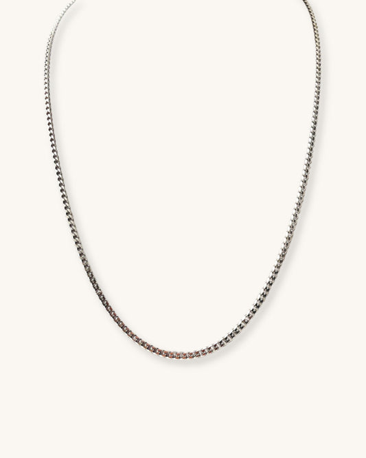 Silver curb chain necklace on a white background