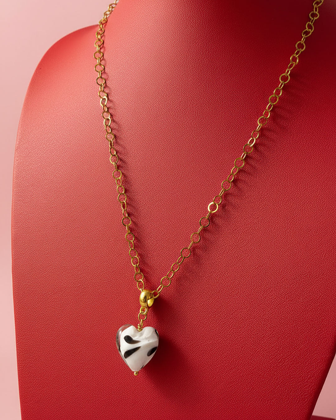 Necklace with a heart-shaped pendant on a red background