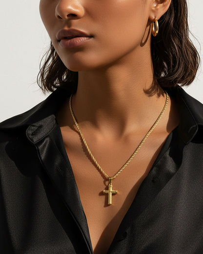 Model wearing a rope chain necklace with a cross pendan in gold