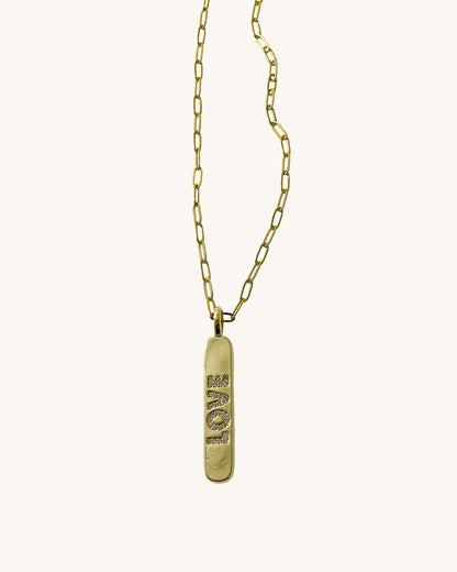 A love engraved tag charm on a dainty paperclip chain in gold