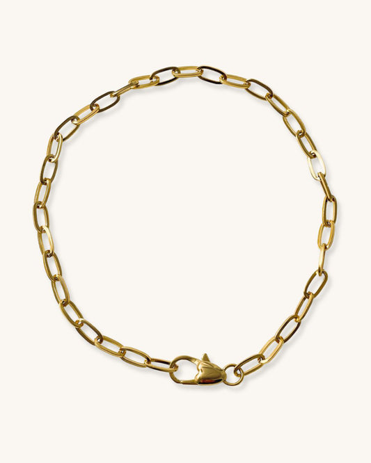 A gold chain necklace with a heart shaped closure. The chain is made of oval-shaped links.
