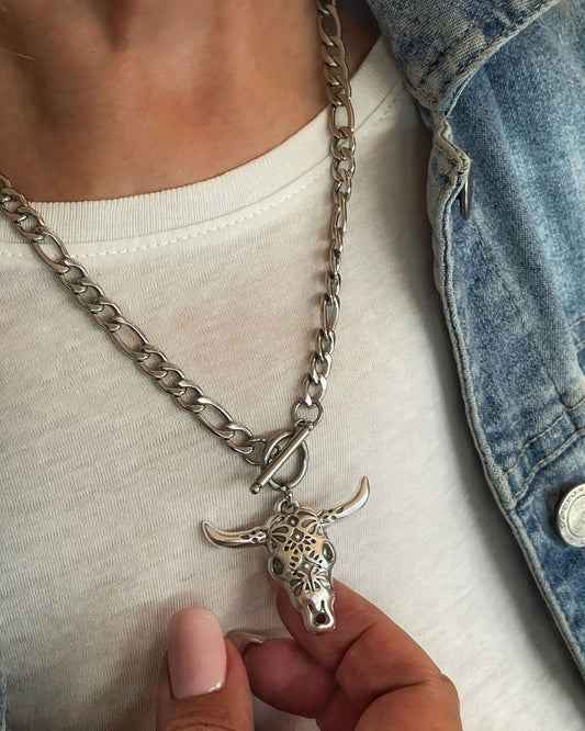 Model wearing a silver necklace with a bull head pendant