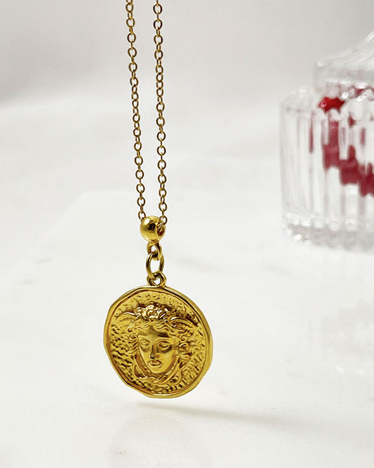 A beautifull gold round medusa head pendant necklace with a stainless steel chain.