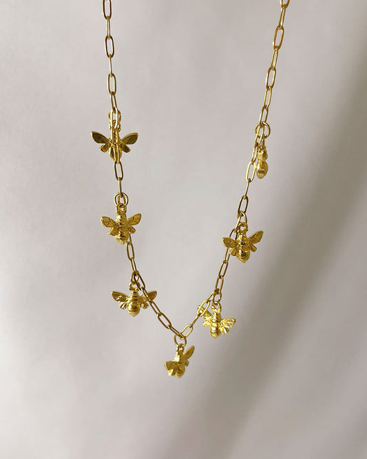 A beautifully multi bee charm necklace on a dainty gold paperclip chain