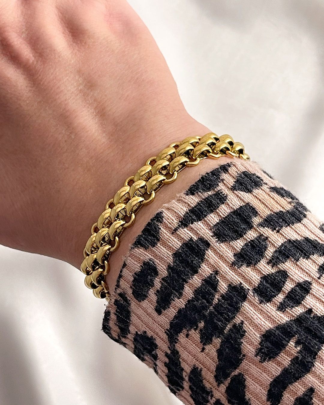 A wide gold woven style chain bracelet made from stainless steel.