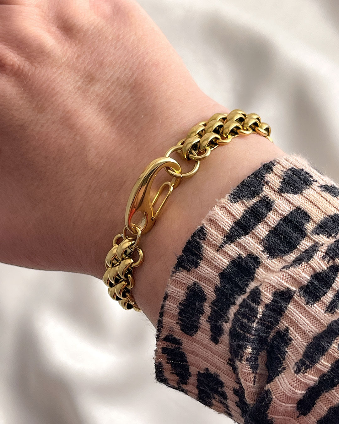 A wide gold woven style chain bracelet made from stainless steel with a large lobster clasp.