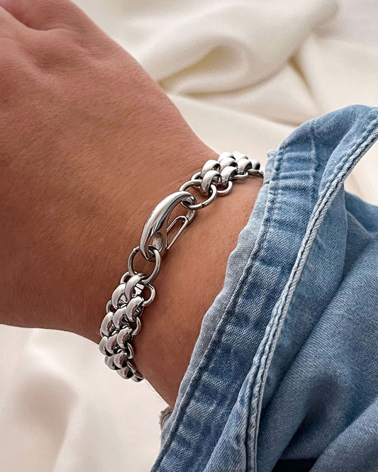 "Palmer" silver chain bracelet on a wrist with a denim jacket sleeve.