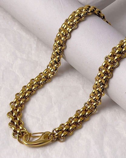 A gold woven wide chain necklace with a large lobster clasp