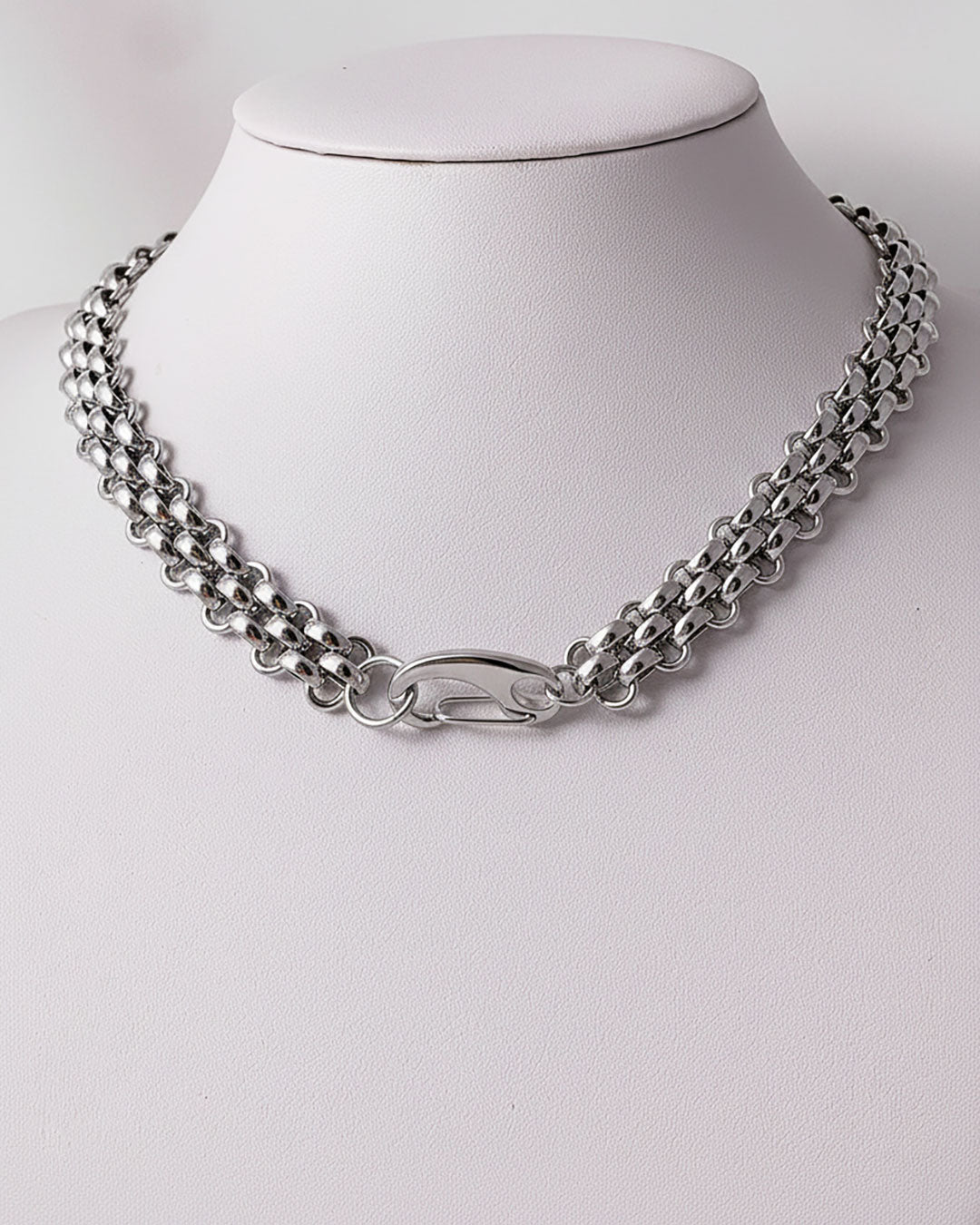 A silver woven wide chain necklace with a large lobster clasp