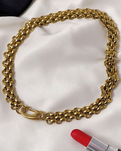 A gold woven wide chain necklace with a large lobster clasp
