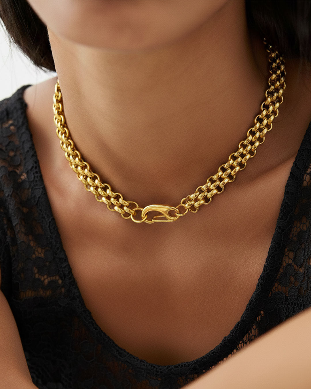 Model wearing a gold chainmail necklace with a large lobster clasp