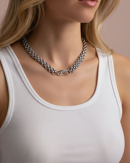 Model wearing a silver chainmail necklace with a large lobster clasp