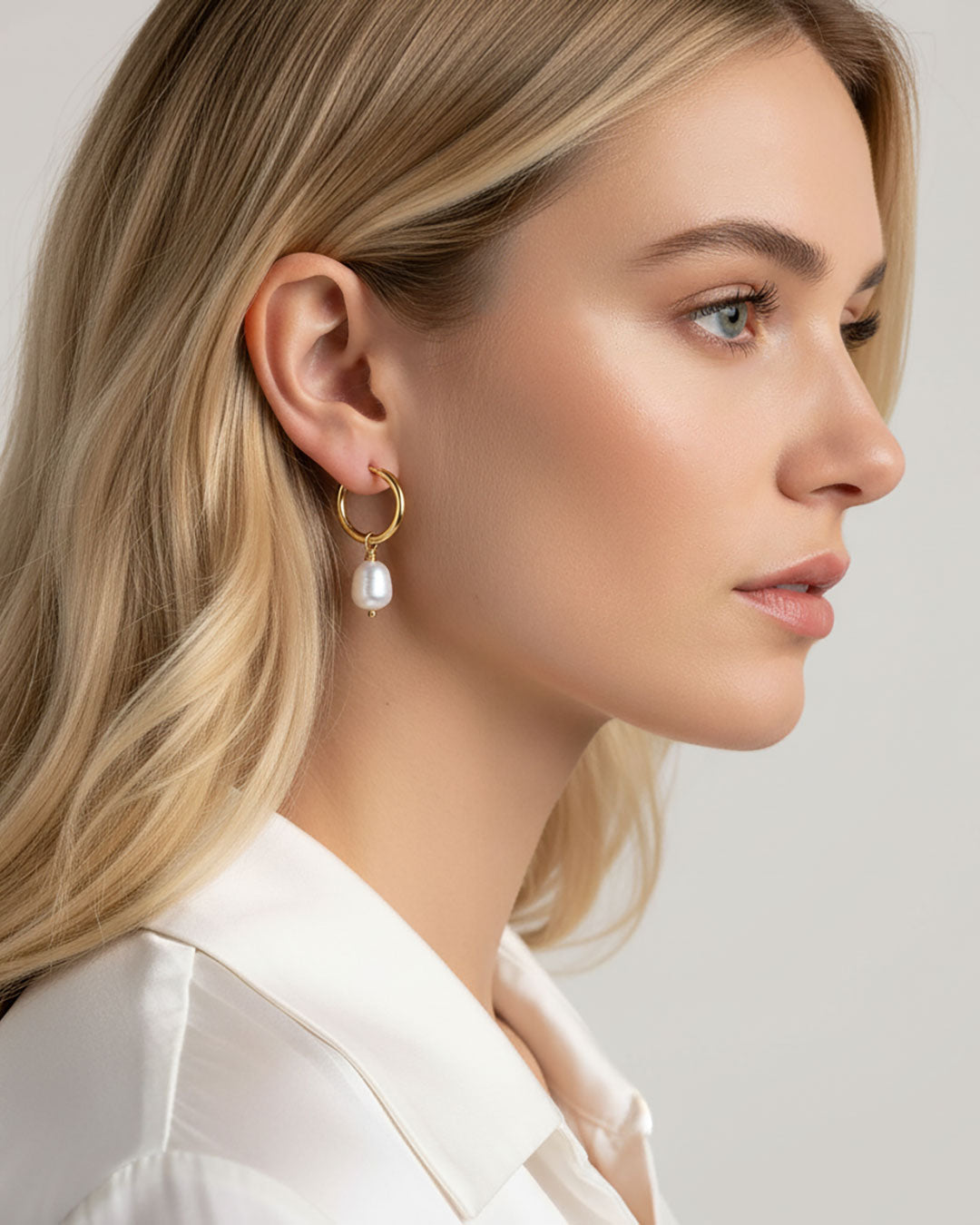 Woman wearing gold hoop earrings with real freshwater pearls