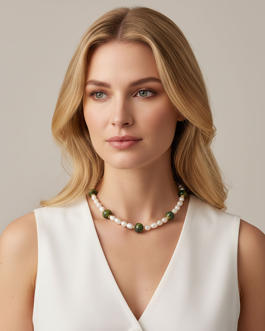 Model wearing a handmade necklace with freshwater pearls and green ceramic beads