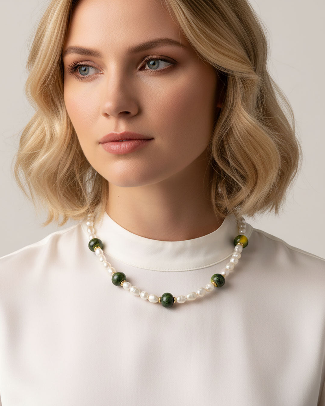 Model wearing a handmade necklace with freshwater pearls and green ceramic beads