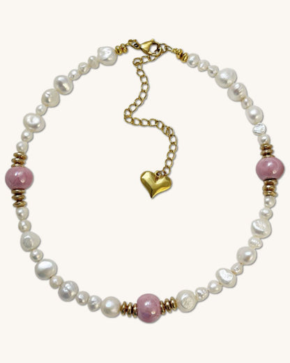 A handmade necklace with freshwater pearls adorned with gold hematite and pink ceramic beads