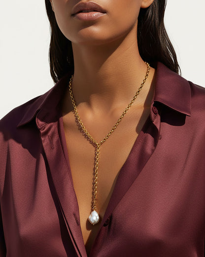 Model wearing a gold chain necklace with a MOP shell pearl pendant