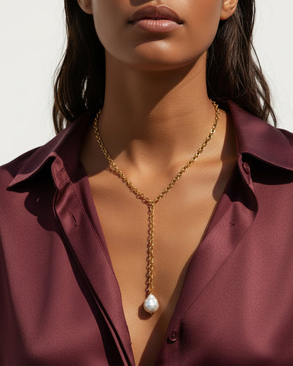 Model wearing a gold chain necklace with a MOP shell pearl pendant