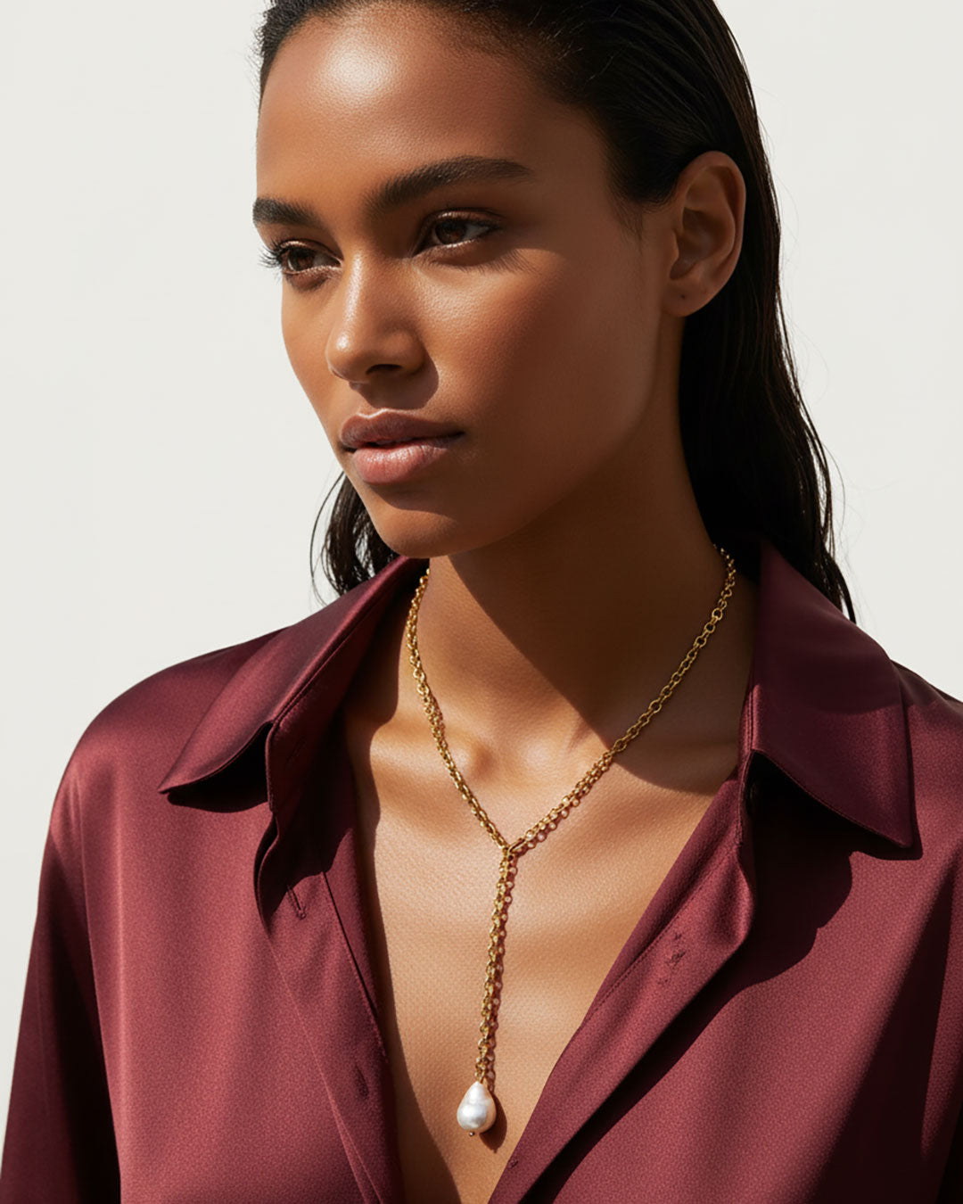 Model wearing a gold chain necklace with a MOP shell pearl pendant