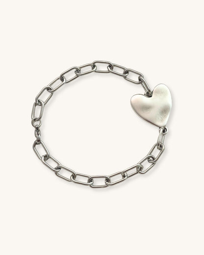 Silver chain bracelet with a heart-shaped charm on a white background