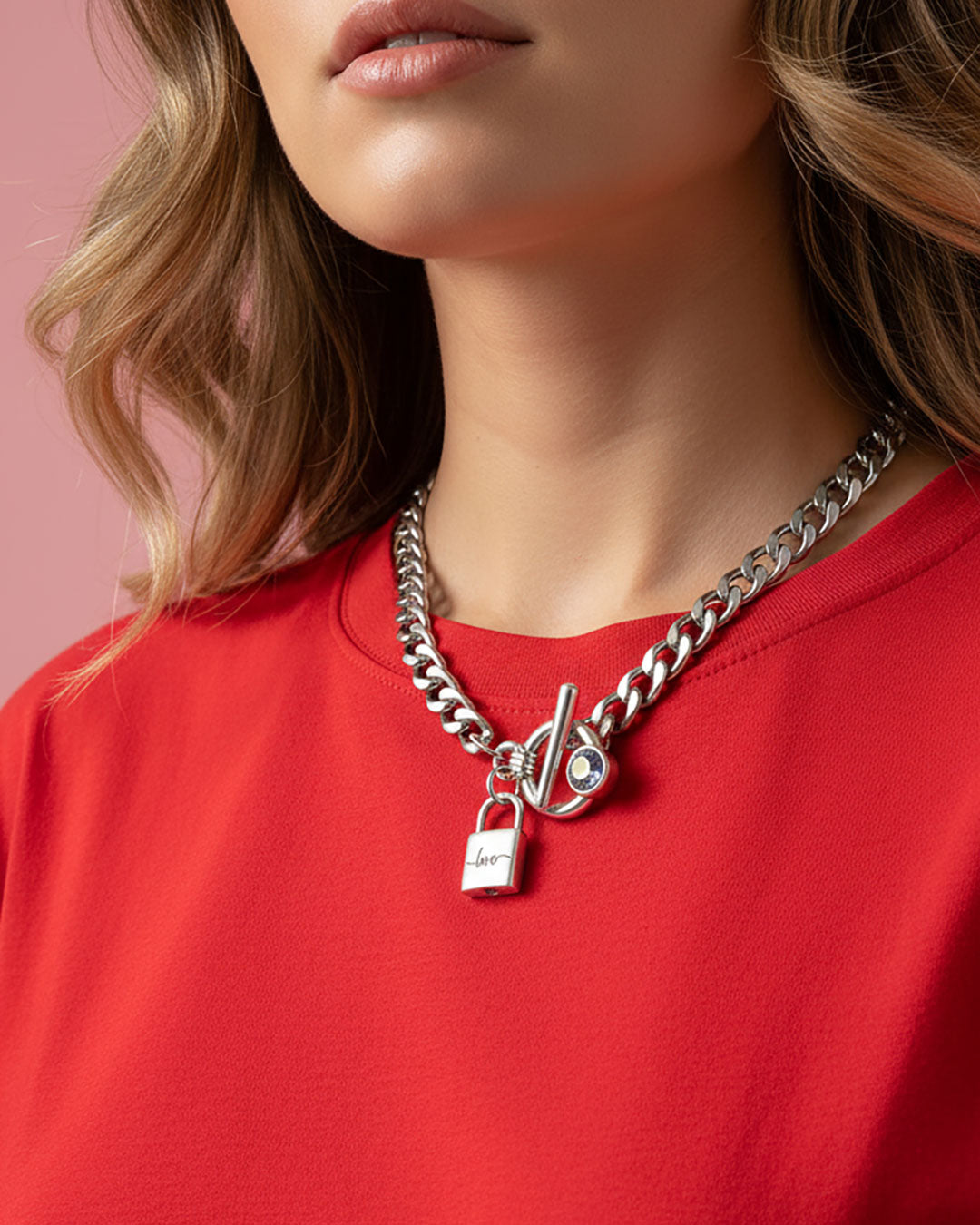 Model wearing a silver chain necklace with a padlock charm that says 'love' and an aquamarine Swarovski crystal toggle clasp.