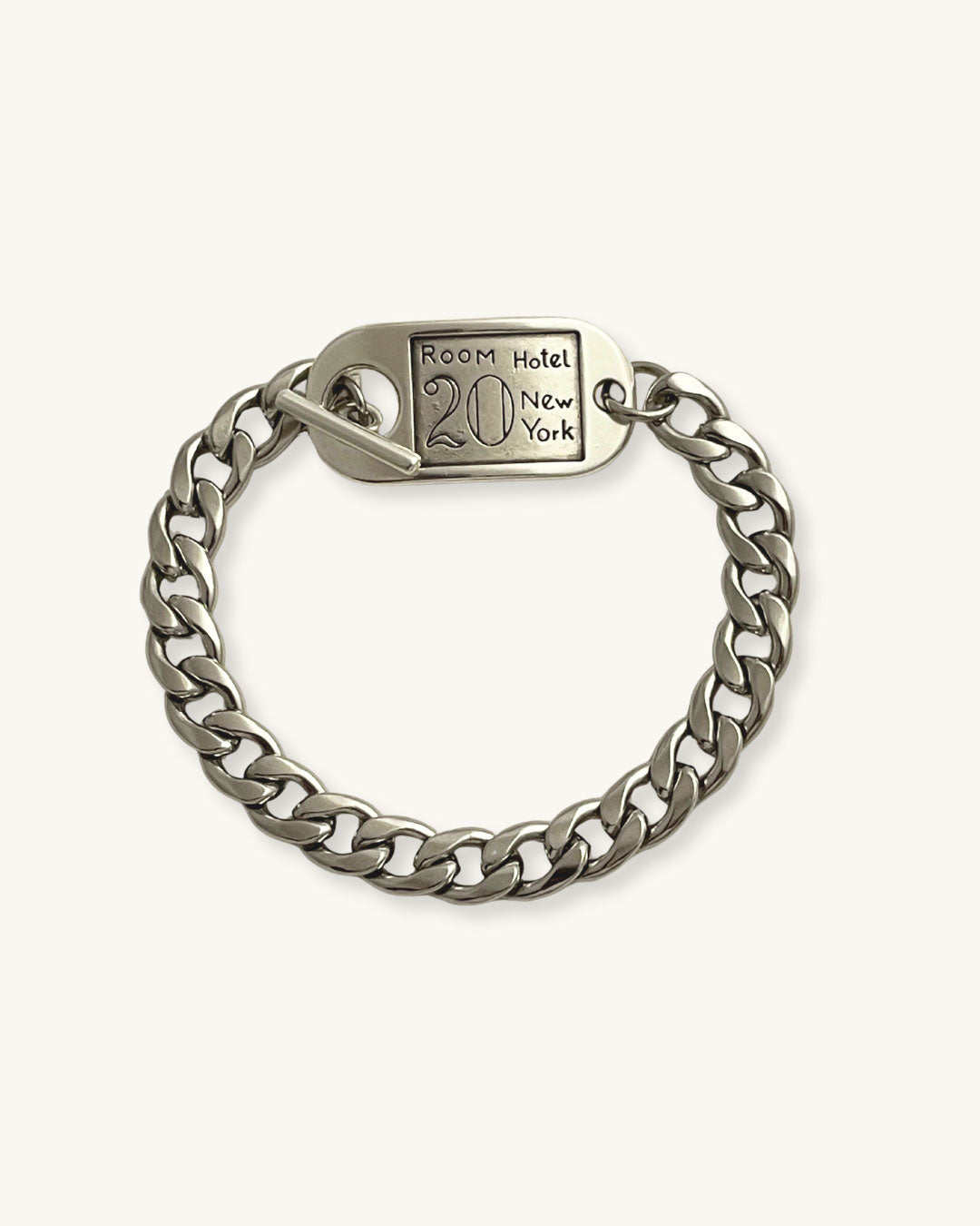 Silver chain bracelet with a toggle tag on a white background