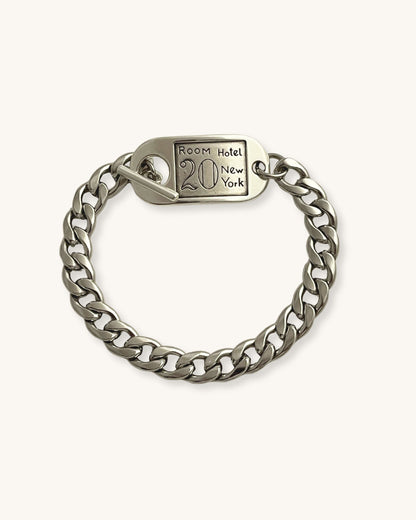 Silver chain bracelet with a toggle tag on a white background