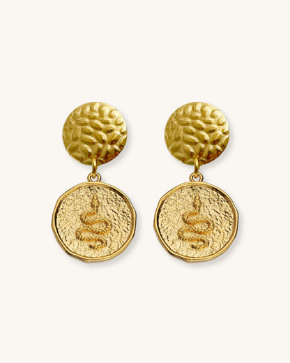 The Snake Earrings, a pair of gold earrings featuring a round snake charm.