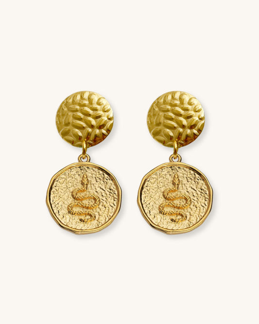 The Snake Earrings, a pair of gold earrings featuring a round snake charm.