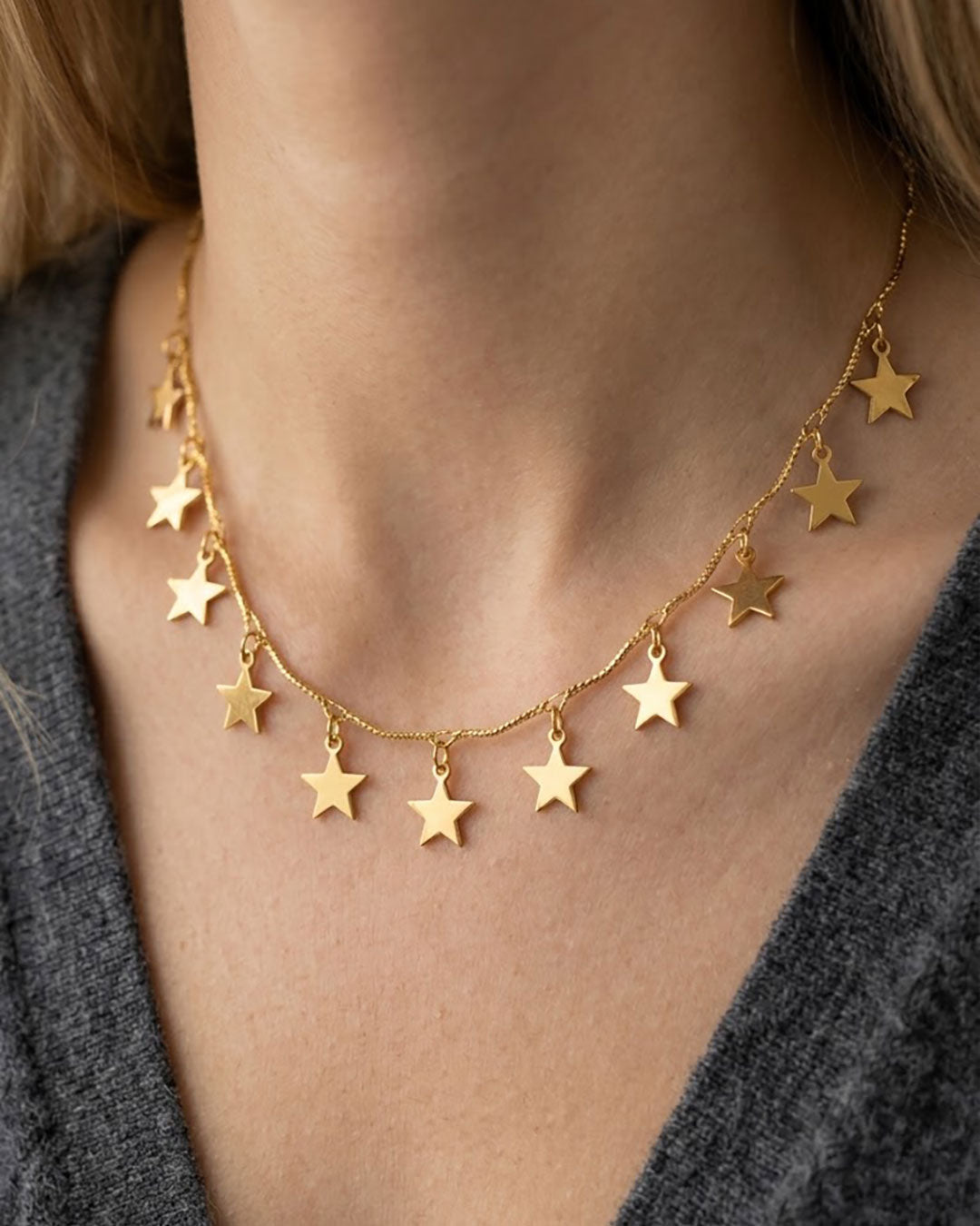 Woman wearing a gold necklace with star charms