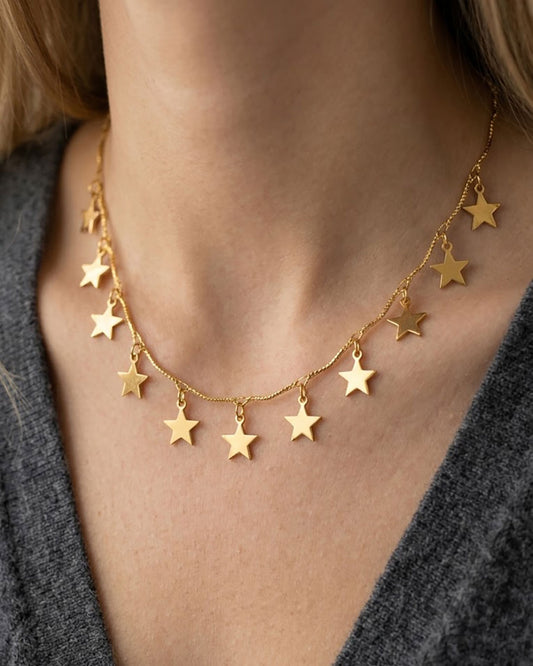 Woman wearing a gold necklace with star charms