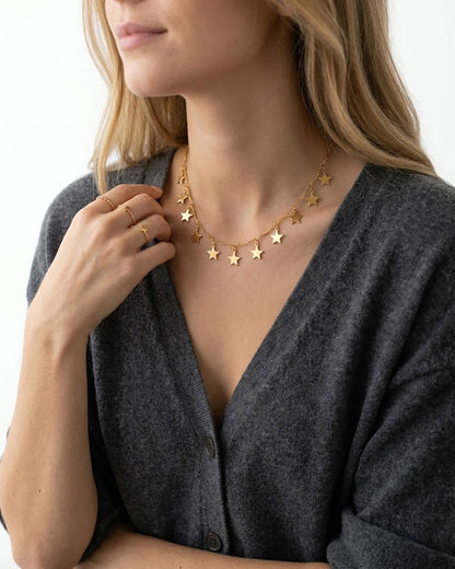 Woman wearing a gold necklace with star charms