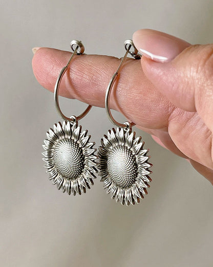 The Sunflower Hoop Earrings, a pair of silver hoop earrings featuring a sunflower charm.